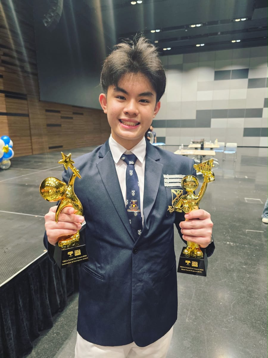 Linus in a suit holding award trophies